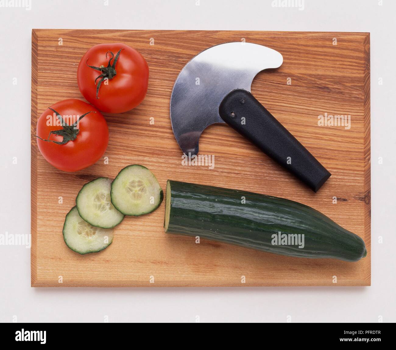 https://c8.alamy.com/comp/PFRDTR/kitchen-knife-with-half-moon-blade-on-chopping-board-with-tomatoes-and-cucumber-PFRDTR.jpg