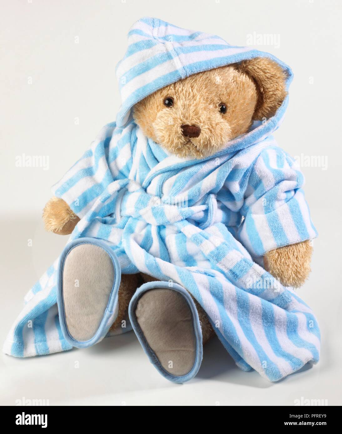 Teddy bear wearing blue and white striped dressing gown and