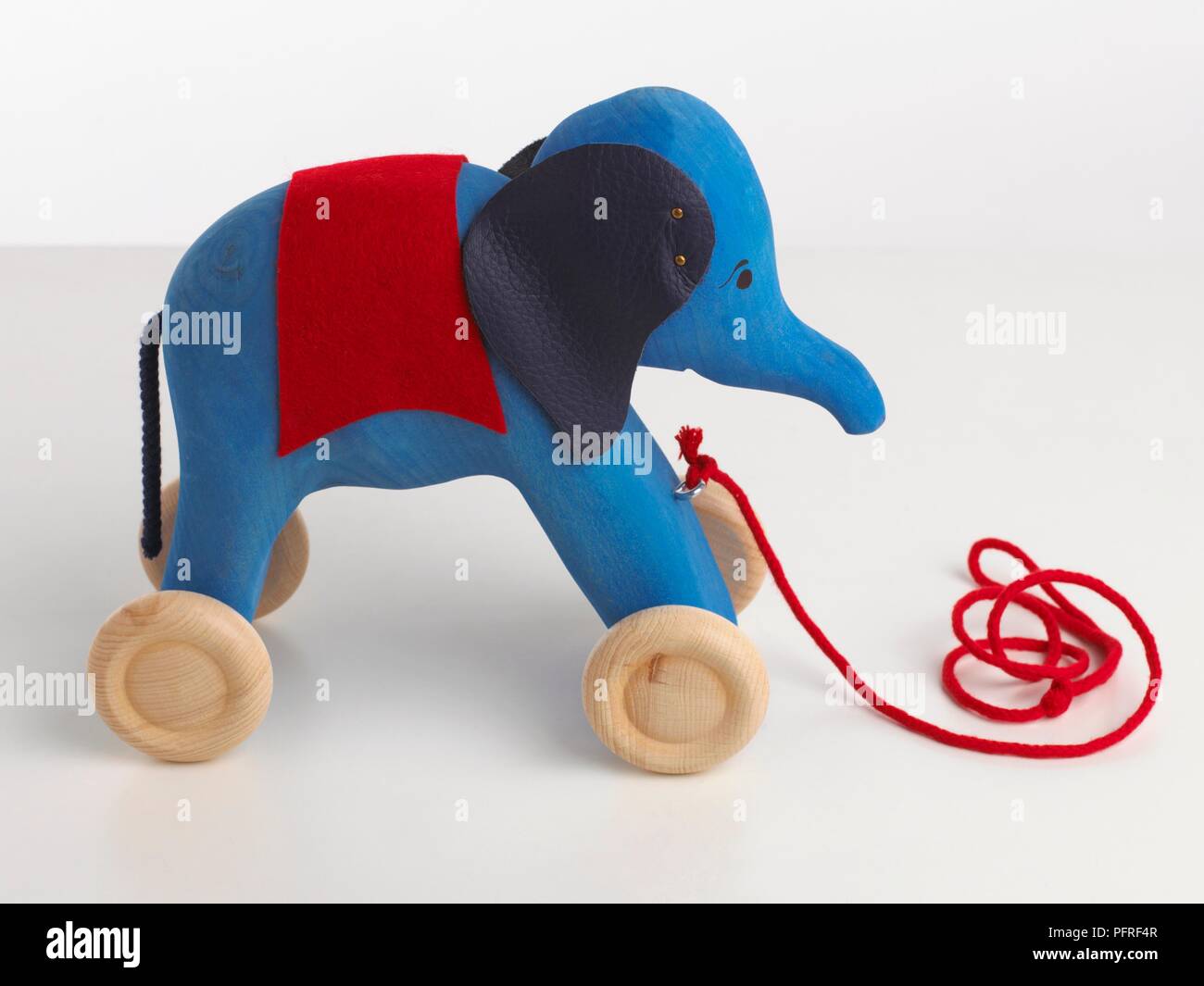 Blue elephant toy on wheels with red string to pull Stock Photo