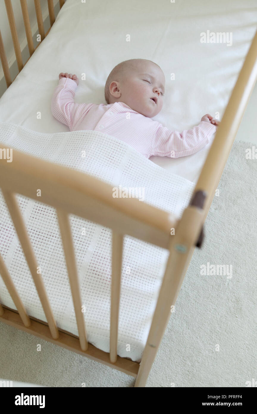 Baby girl asleep in cot Stock Photo Alamy