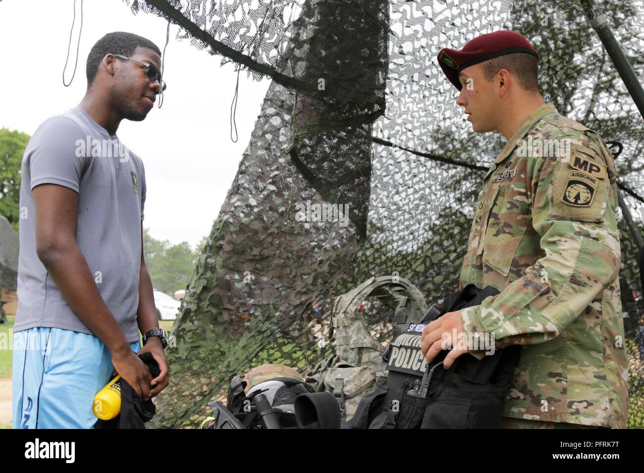 Treyton Reid, a future Soldier with the Raleigh Recruiting Battalion, and a military policeman talk about Soldiers’ equipment and responsibilities during the 82nd Airborne Division’s Airborne Review at Sicily Drop Zone, Fort Bragg, North Carolina, May 24, 2018. Approximately 350 future Soldiers and recruiters from Raleigh Recruiting Battalion attended the Airborne Review and toured Fort Bragg during All American Week. Stock Photo