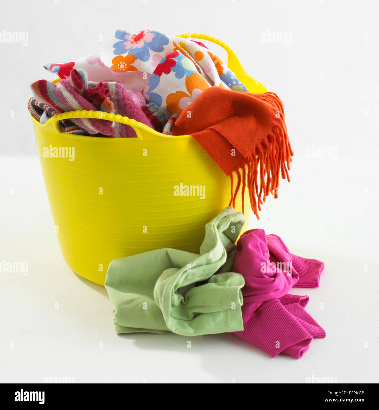 Plastic yellow basket full of clothes Stock Photo Alamy