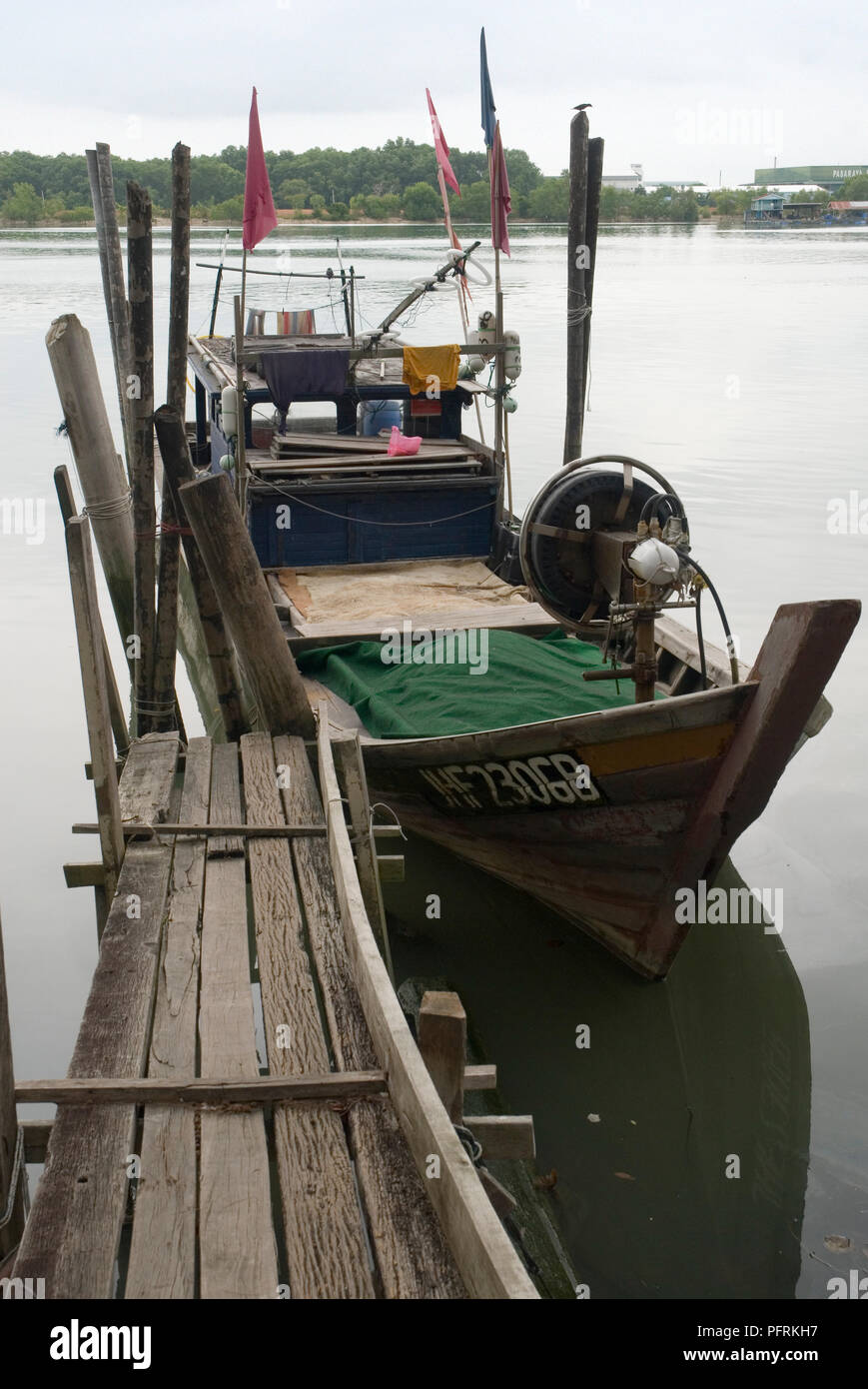 Malaysia, Johor, Muar, fishing boat moored at small wooden pier at mouth of Muar River Stock Photo