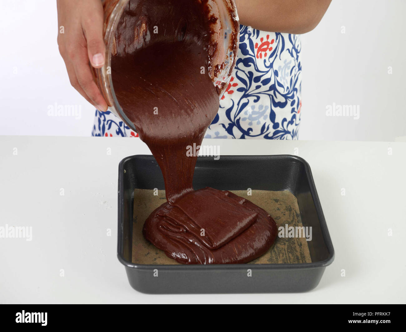 Pouring chocolate brownie mixture into baking tin Stock Photo Alamy
