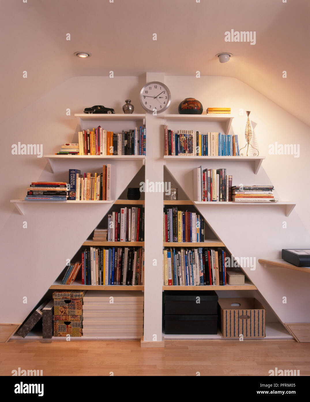 https://c8.alamy.com/comp/PFRM05/a-triangular-space-around-a-chimney-flue-with-shelves-full-of-books-and-boxes-PFRM05.jpg
