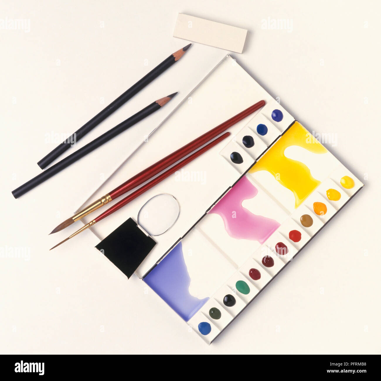 Watercolour palette with paintbrushes, pencils, and eraser Stock Photo