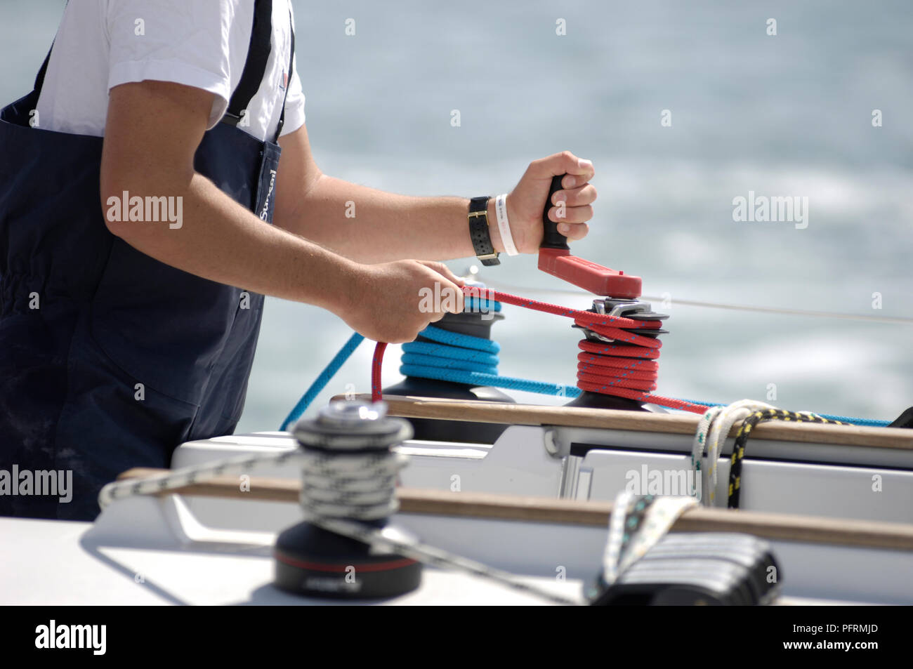 Person on boat winding rope around capstan Stock Photo