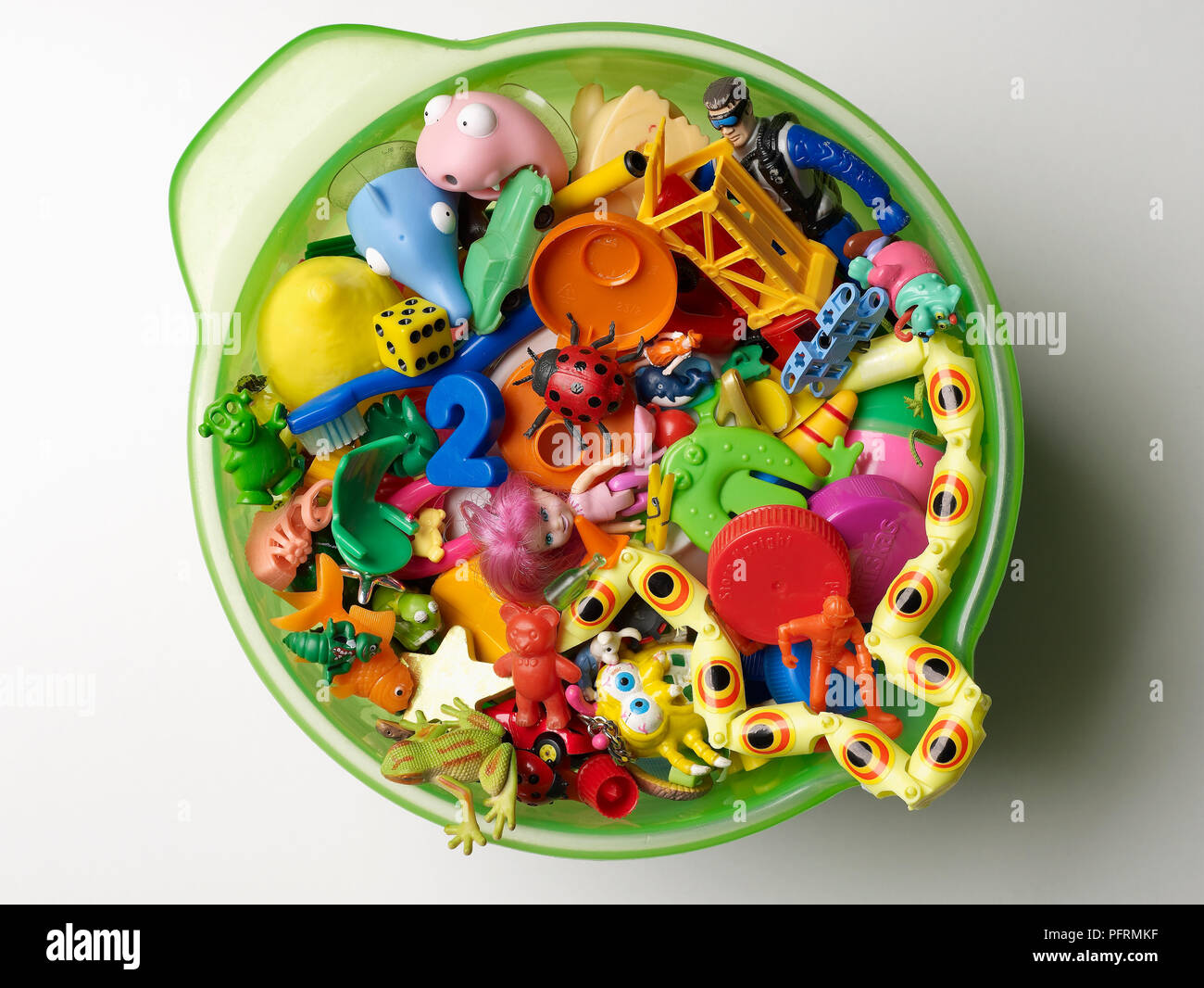Plastic green bowl full of small plastic toys Stock Photo Alamy