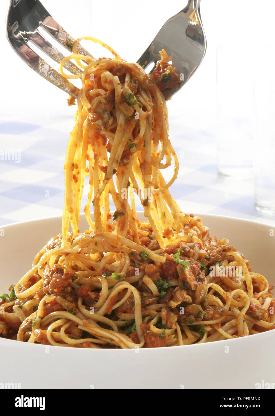 Two serving forks lifting linguine alle vongole from bowl Stock Photo Alamy