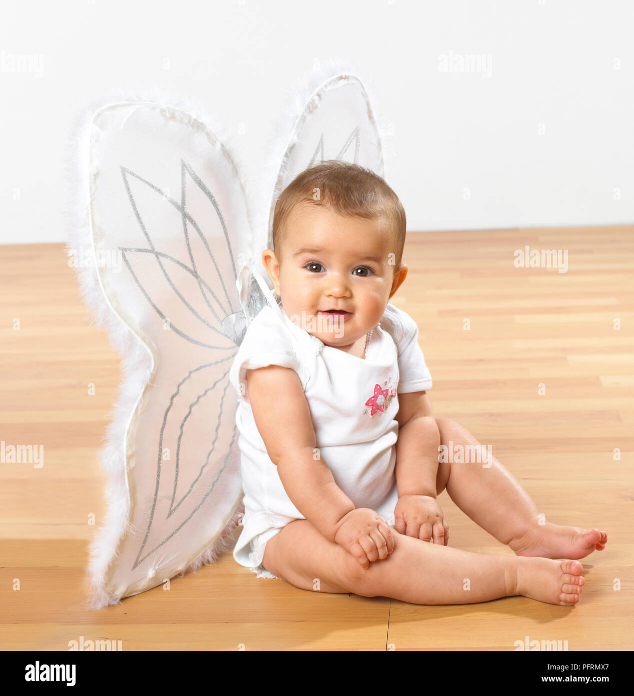 A baby girl dressed in white butterfly wings Stock Photo Alamy