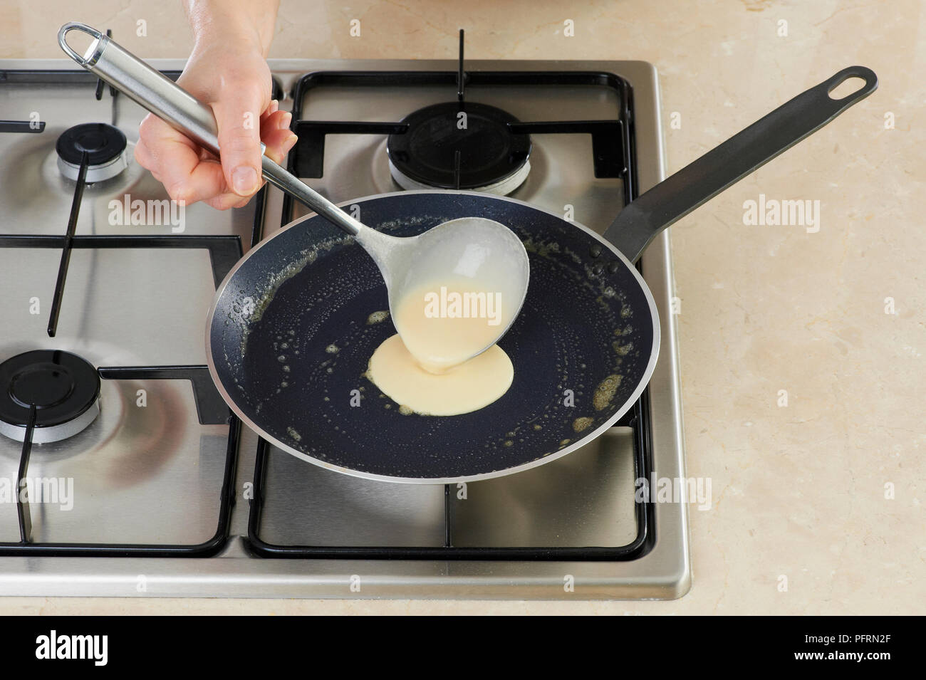Ladling crepe batter into frying pan Stock Photo Alamy