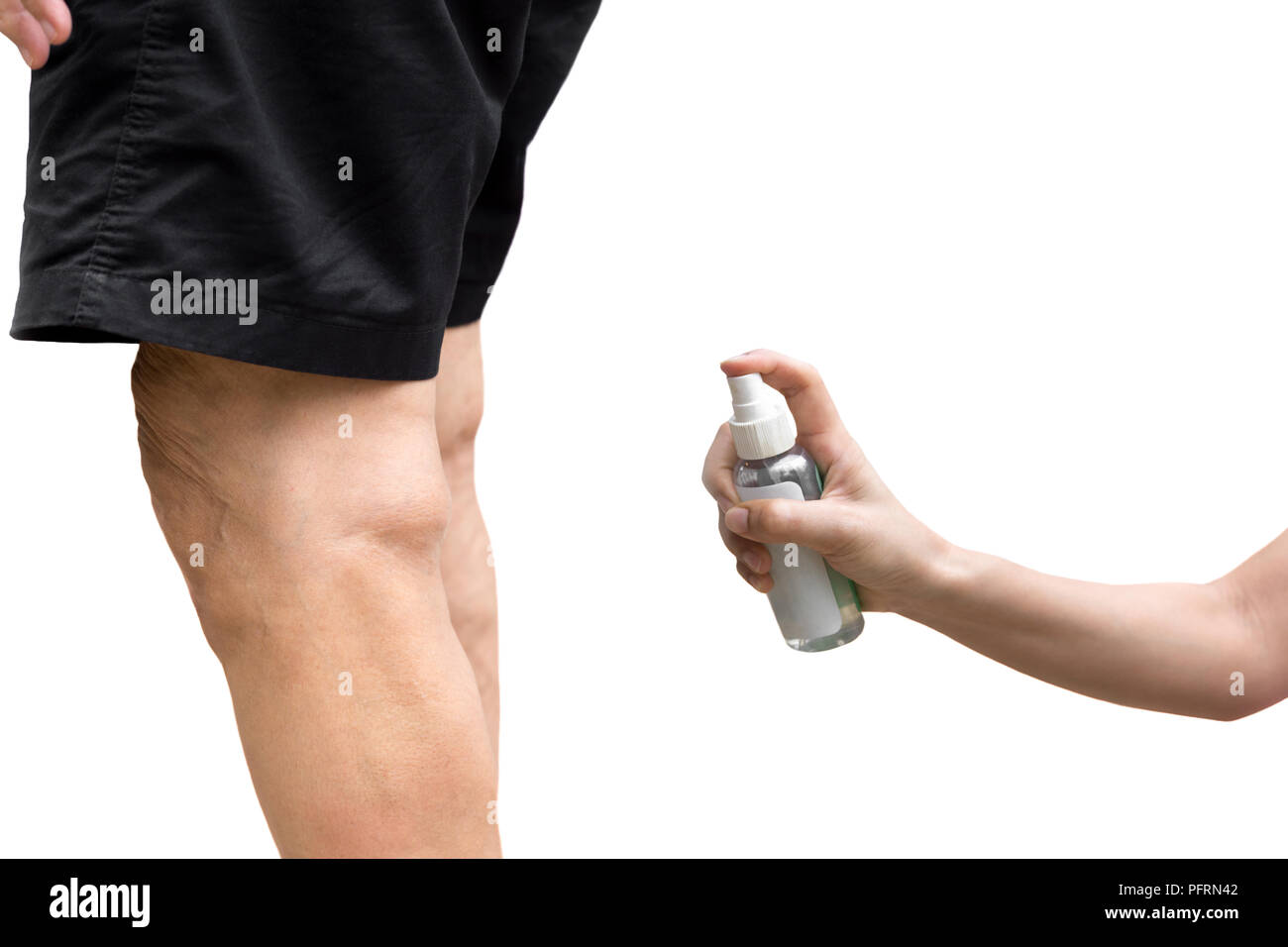 Daughter spraying insect repellent on here mother is legs outdoo Stock Photo