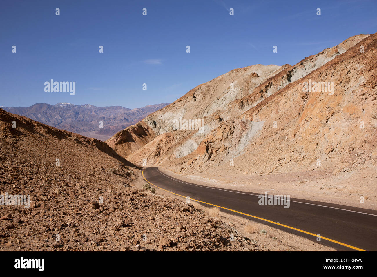 USA, California, Death Valley, new road through arid landscape at Artist's Palette with blue sky above Stock Photo