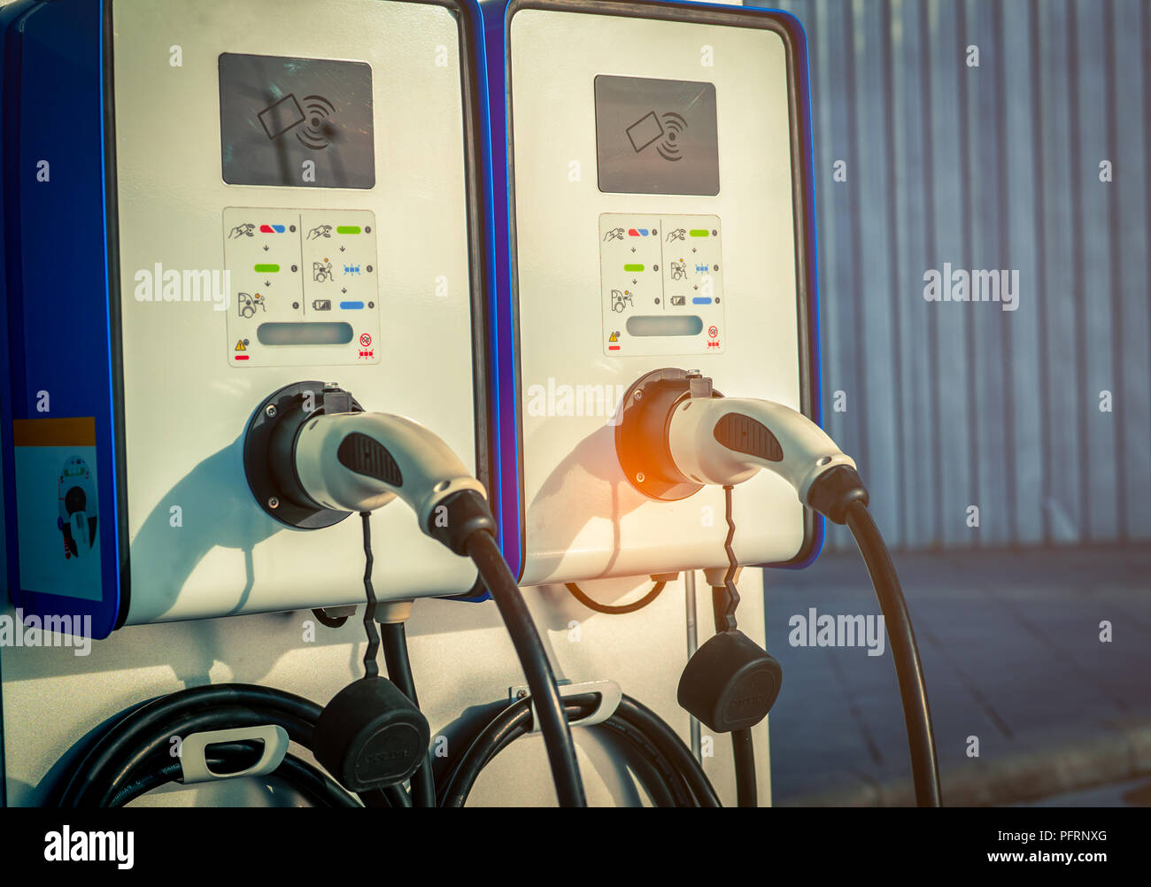 Electric car charging station. Plug for vehicle with electric motor. Coin-operated charging station. Clean energy power. Commercial charging station.  Stock Photo