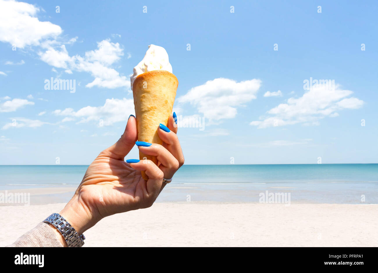 Hand holding ice cream cone on the beach with blue sky Stock Photo - Alamy