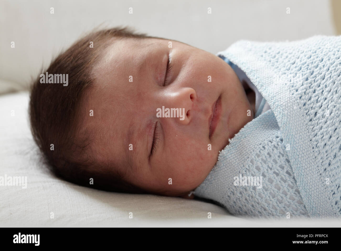 Baby boy (3 weeks) swaddled in blanket Stock Photo