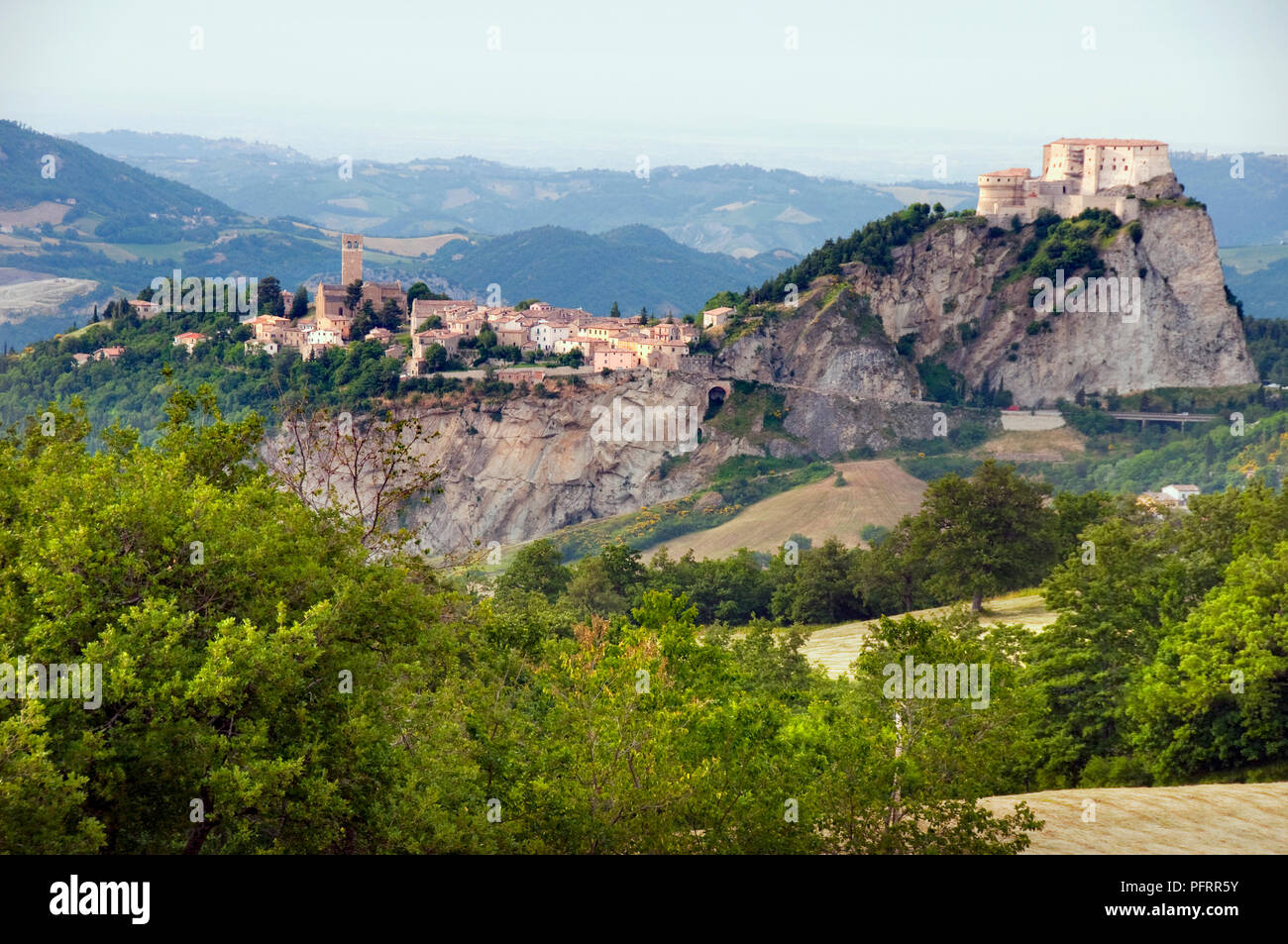Italy, Emilia-Romagna, Rimini, San Leo, countryside and landscape with town built on mountain in distance Stock Photo