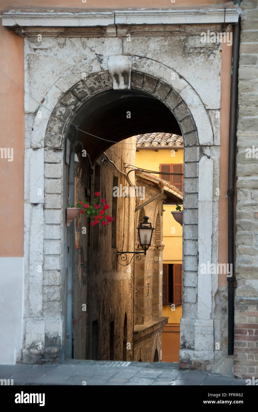 Italy, Marche, Arcevia, old arched entrance leading down to street below Stock Photo