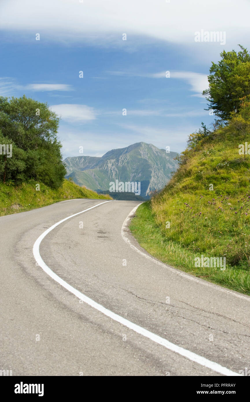 Italy, Emilia-Romagna, Parma, winding road on route to Langhirano with mountains in background Stock Photo