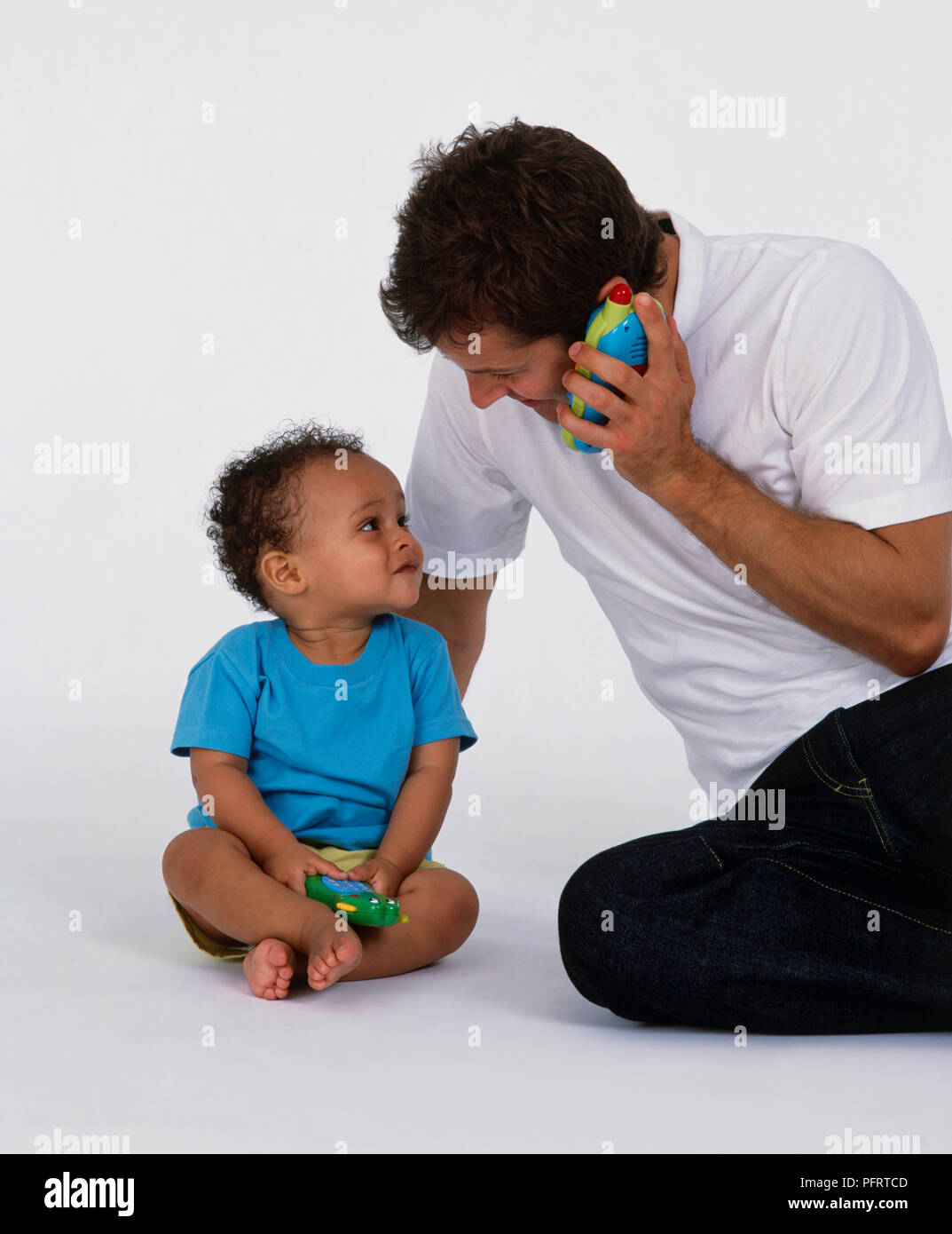Father and son playing with toy telephones Stock Photo