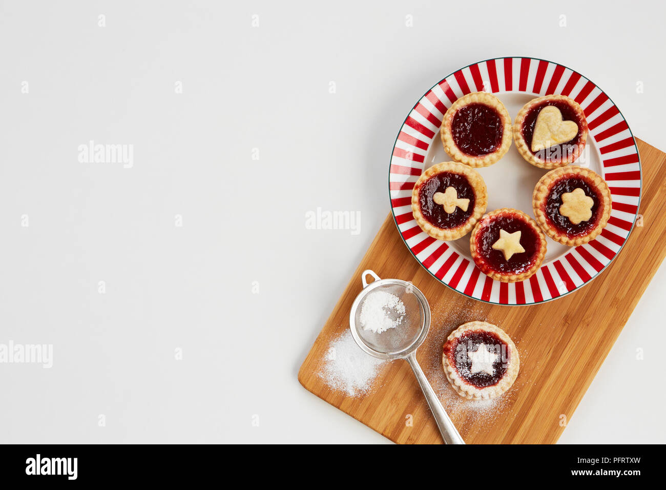 Plate of jam tarts on a wooden board Stock Photo