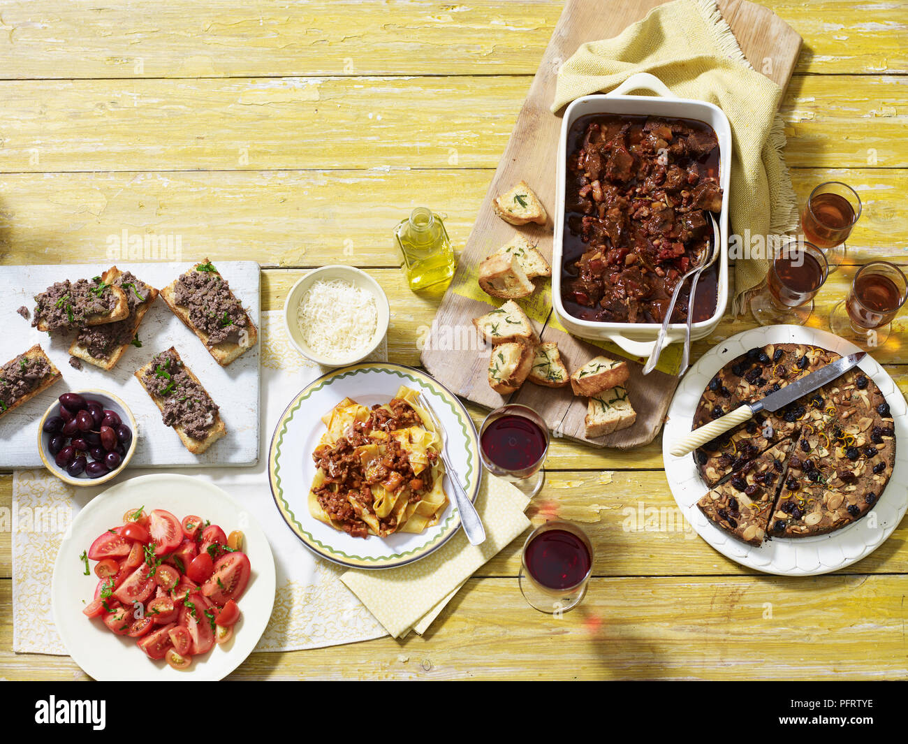 Tuscan autumn supper, including crostini di fegatini (chicken liver), pappardelle al ragu, spezzatino di manzo (beef stew), castagnaccio chestnut cake Stock Photo