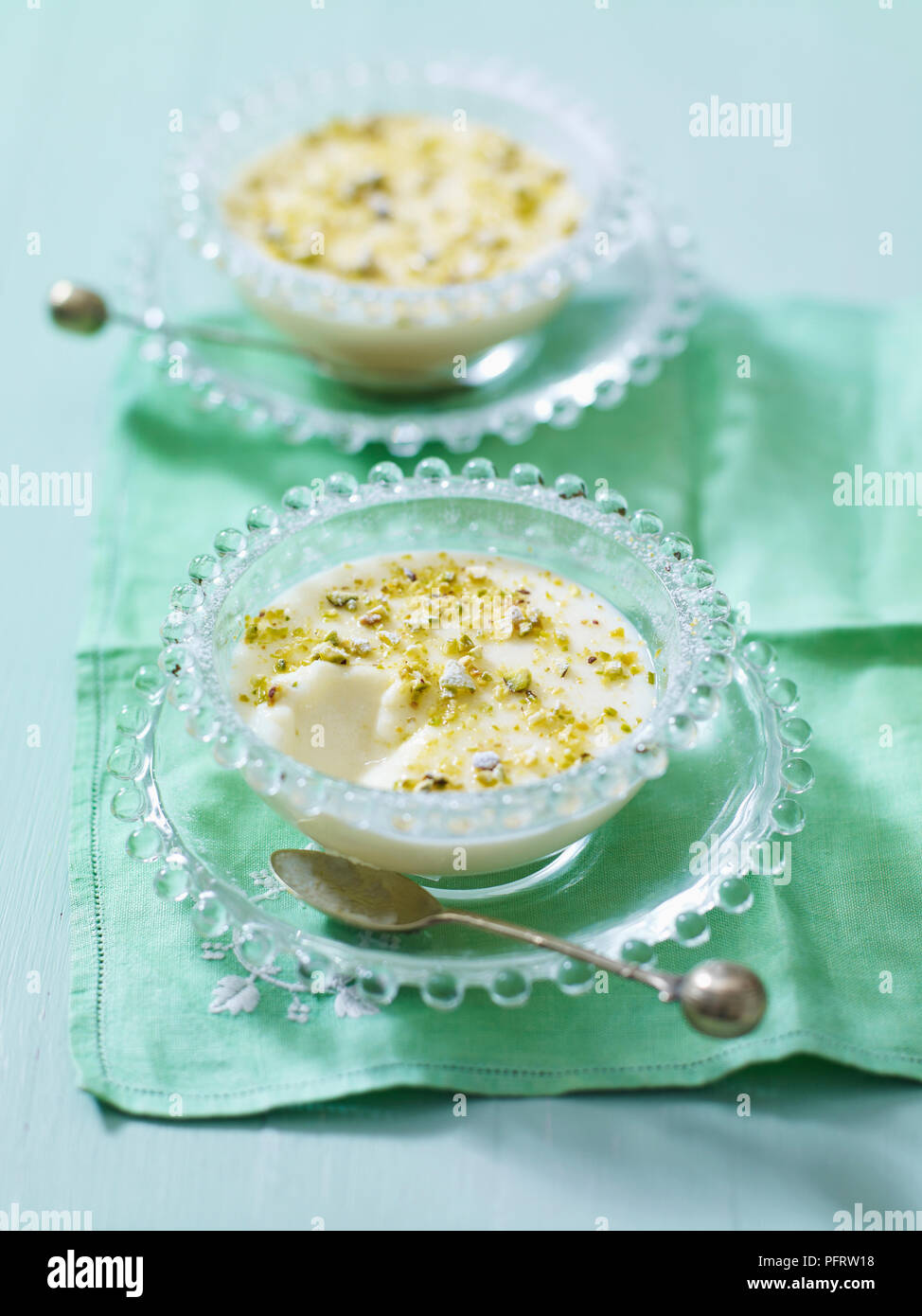 Muhallabia, Middle Eastern milk pudding sprinkled with pistachio nuts Stock Photo