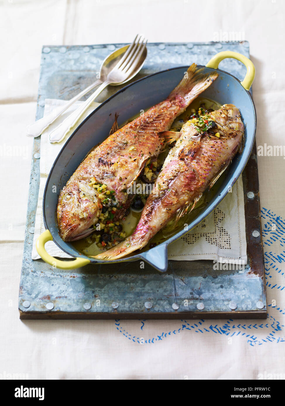 Triglie de scoglio, pan-fried red mullet, stuffed with preserved lemons, olives, parsley Stock Photo