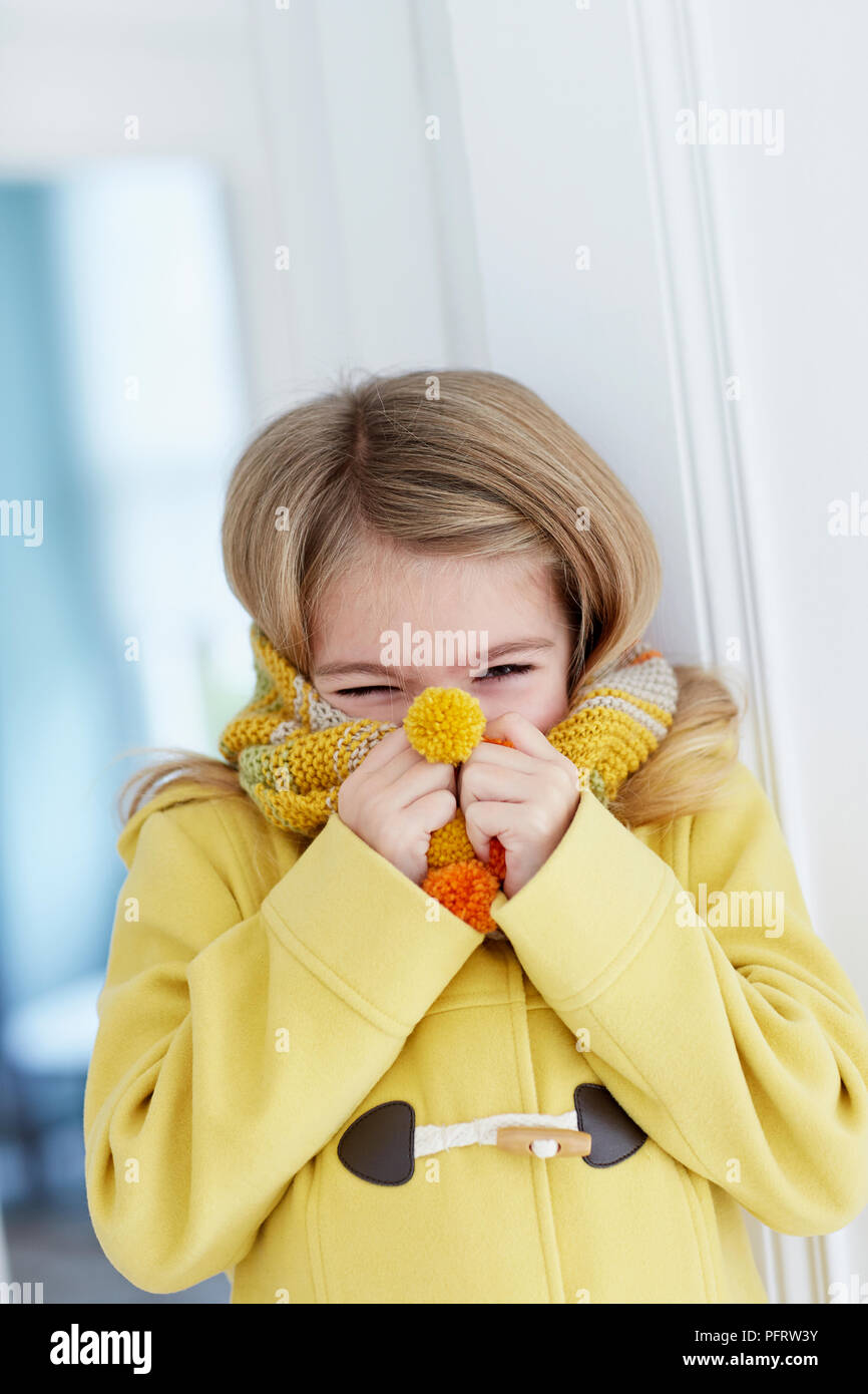 Girl (5 years) with stripy knitted scarf wrapped around her face Stock Photo