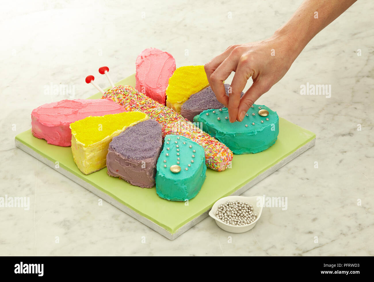 Decorating butterfly cake with edible beads Stock Photo