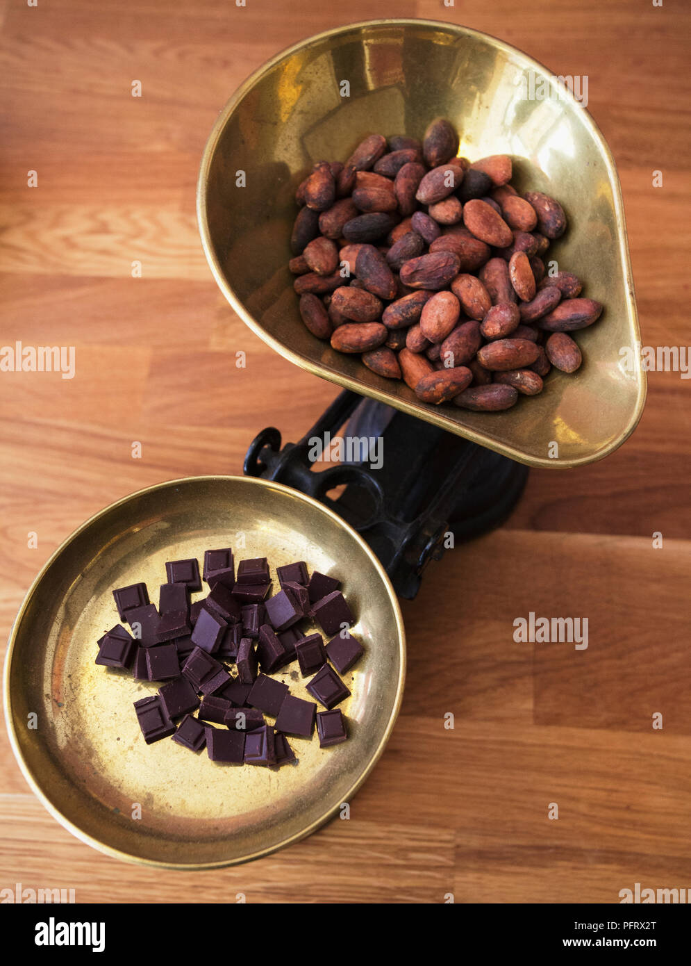 Chocolate bars and cocoa beans on scales Stock Photo