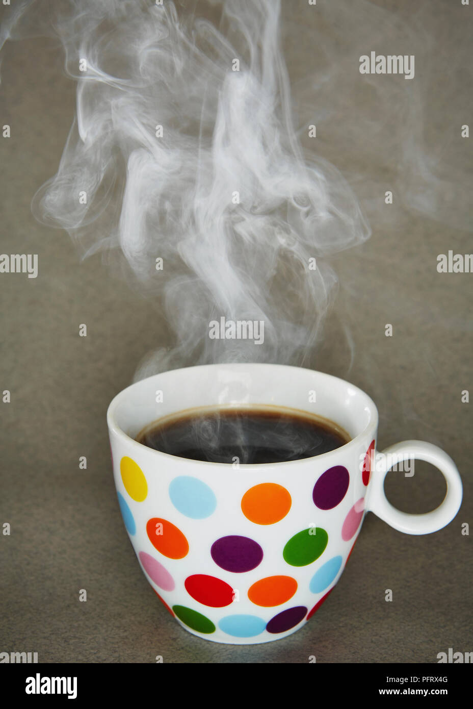 Spotty mug of a hot drink steaming Stock Photo