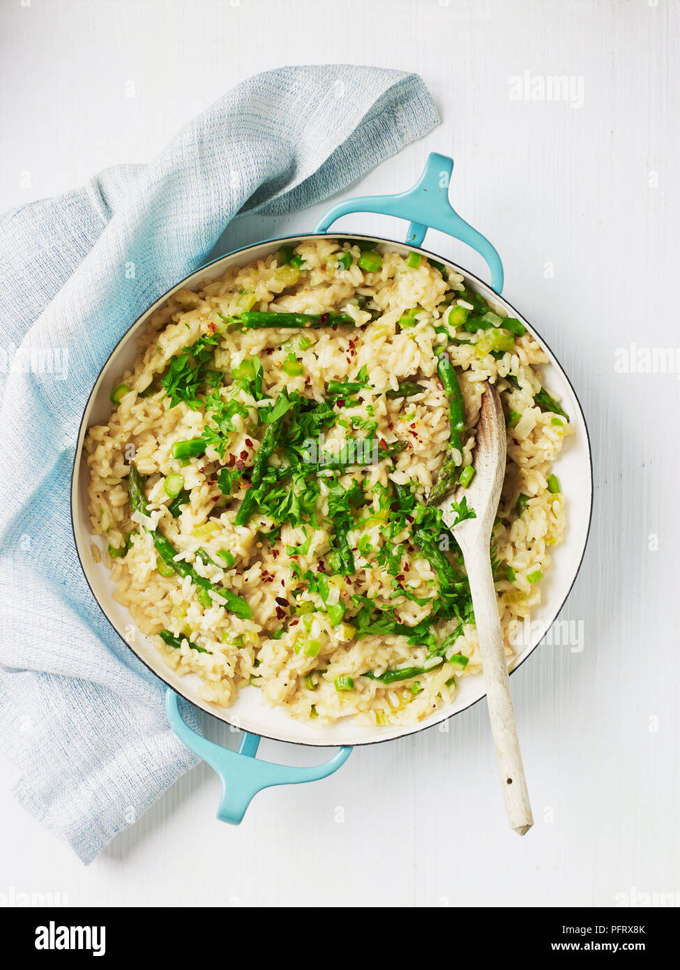 Vegetable risotto in a large pan with wooden spoon Stock Photo