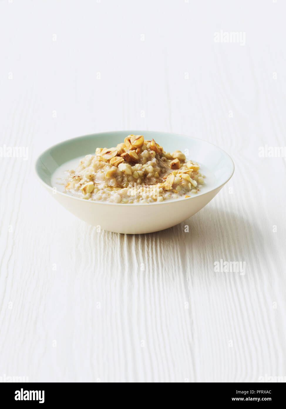 Buckwheat porridge with maple syrup and toasted hazelnuts Stock Photo
