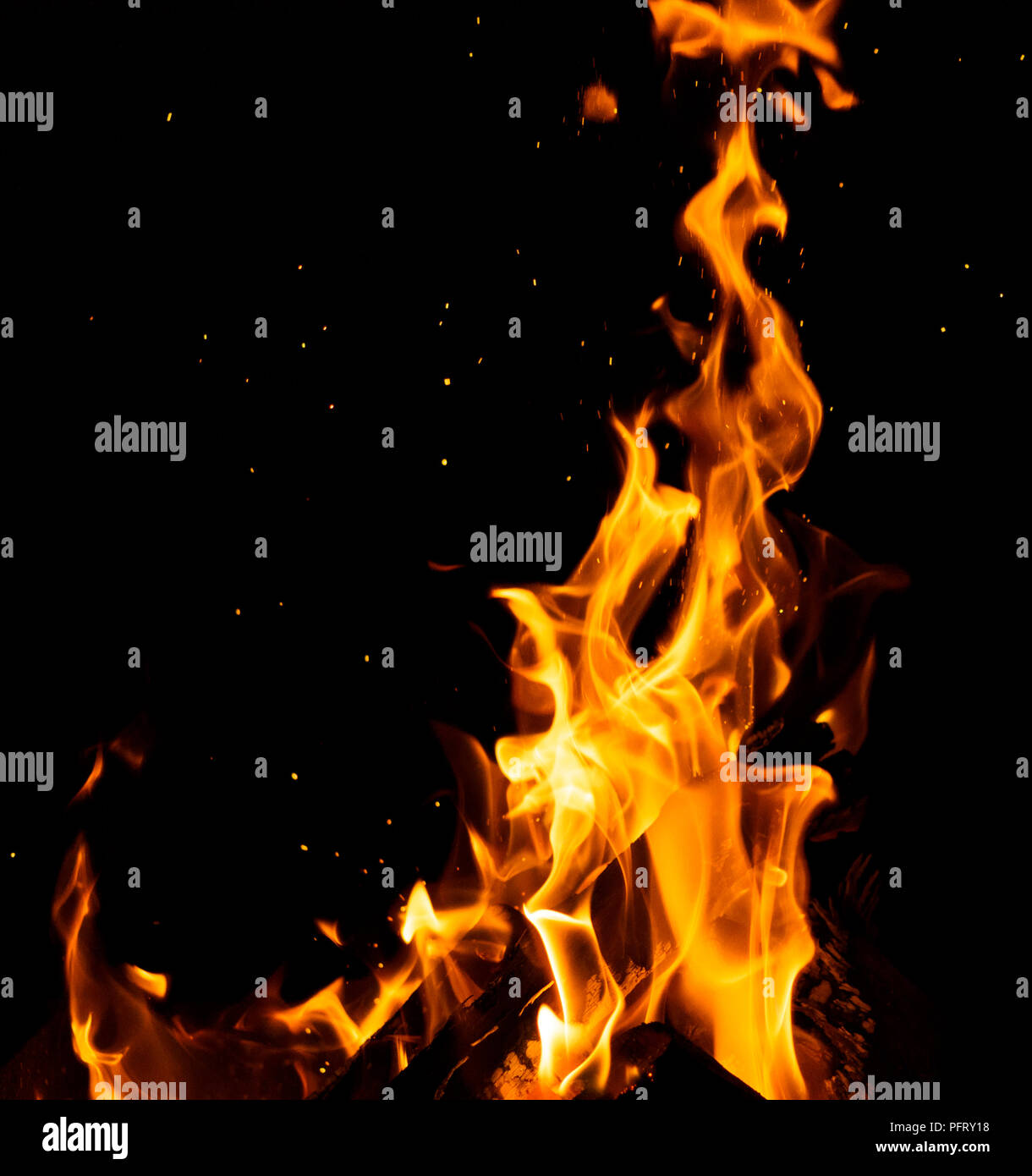 burning wooden logs with high flames and sparks on a black background ...
