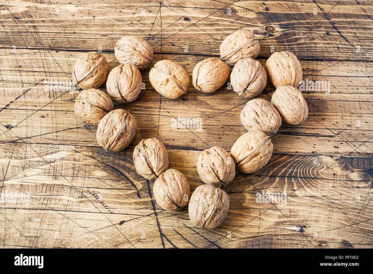 Walnuts in a heart shape on dark vintage wooden background. Healthy walnut nutrition Stock Photo