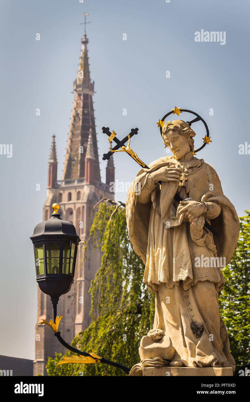 Brugge, Belgium - May 25, 2018 - Statue of John of Nepomuk (or Saint Joannes Nepomucenus), Priest and Martyr, on the bridge over river Dijver Stock Photo