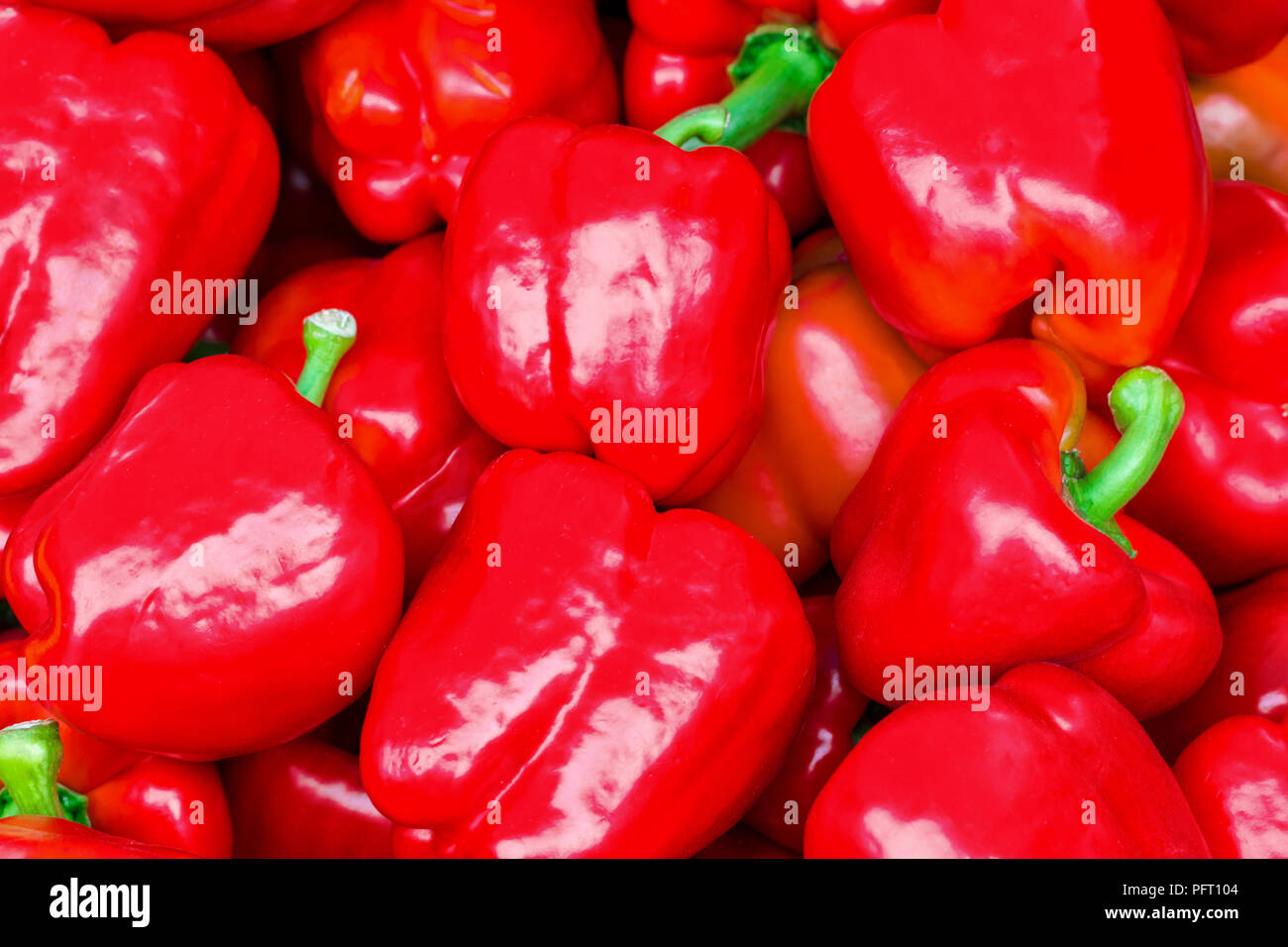 Red bell peppers on a counter in the supermarket. A large number of red ...