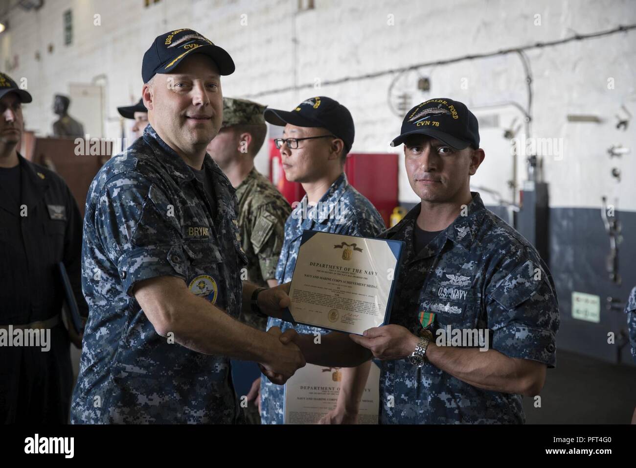 NORFOLK, Va. (May 24, 2018) -- Aviation Structural Mechanic 1st Class Francisco Quezada, from Houston, assigned to USS Gerald R. Ford’s (CVN 78) aviation intermediate maintenance department, receives a Navy and Marine Corps Achievement Medal certificate from Cmdr. Steven Bryant, Ford’s maintenance officer, during an awards ceremony in the ship’s hangar bay. Stock Photo