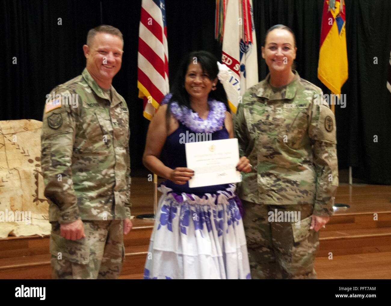 Col. Christopher Lindner, acting commander, William Beaumont Army Medical Center, and Command Sgt. Maj. Janell Ray, command sergeant major, WBAMC, present Tina “TuTu” Hendrix, who performed a traditional Polynesian dance during the Fort Bliss Asian American Pacific Islander Heritage Month observance, a token of appreciation during the observance at the Centennial Banquet and Conference Center, Fort Bliss, May 23. Stock Photo