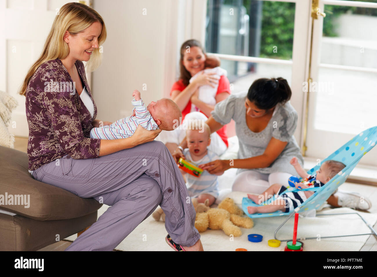 A group of women with three to eight month old babies, socialising and
