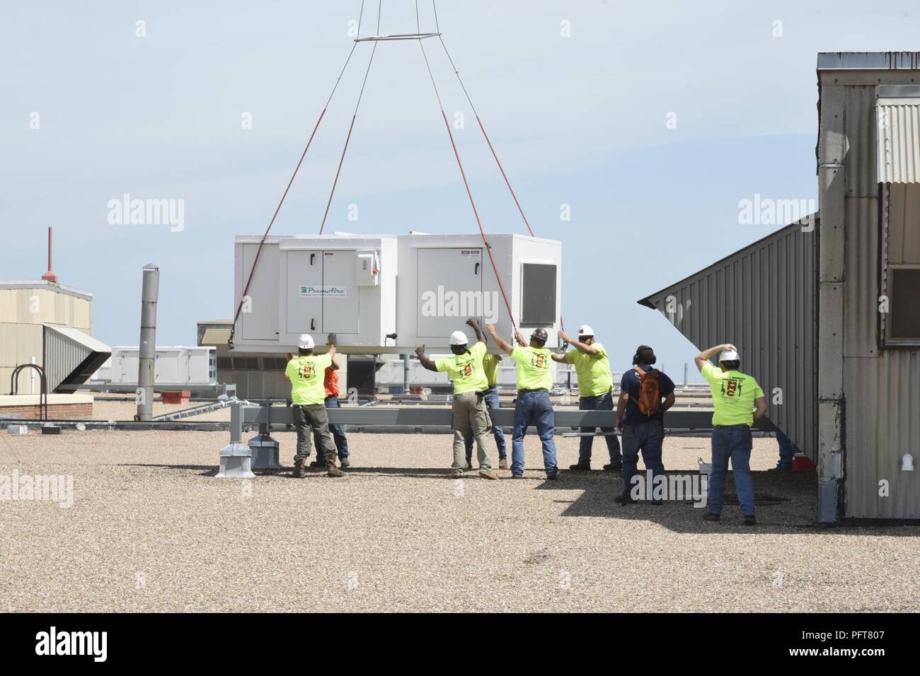 Tradesmen from Matherly Mechanical contractors position a large heating