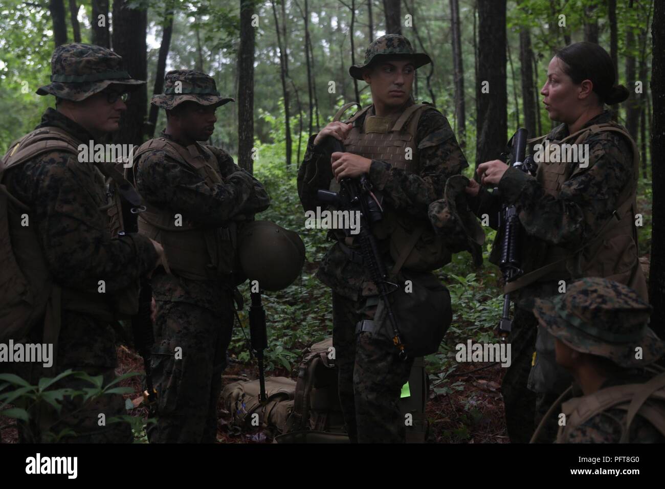 U.S. Navy Sailors attending Field Medical Training Battalion-East, discuss squad tactics during a final exercise (FINEX) at Camp Johnson, N.C., May 29, 2018. FINEX is a culminating event which transitions Sailors into the Fleet Marine Force. Stock Photo