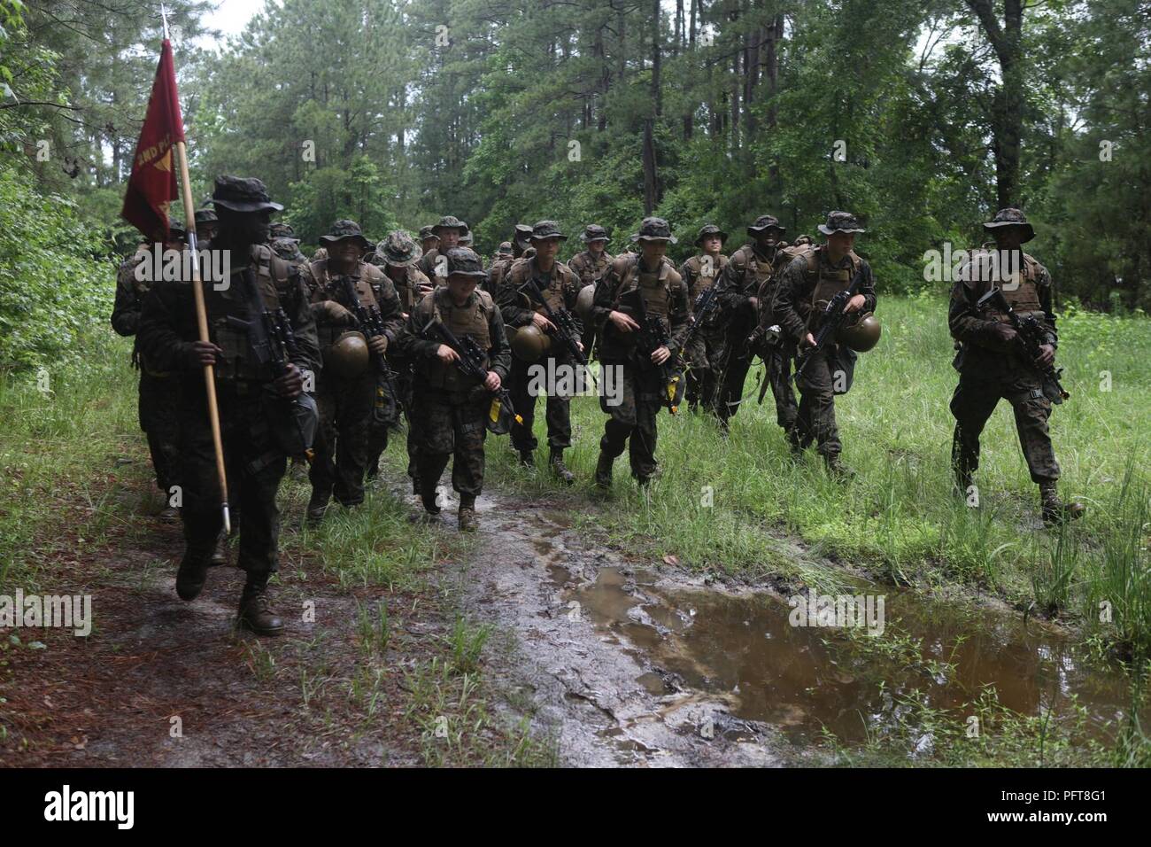 U.S. Navy Sailors attending Field Medical Training Battalion-East, march toward their next objective during a final exercise (FINEX) at Camp Johnson, N.C., May 29, 2018. FINEX is a culminating event which transitions Sailors into the Fleet Marine Force. Stock Photo