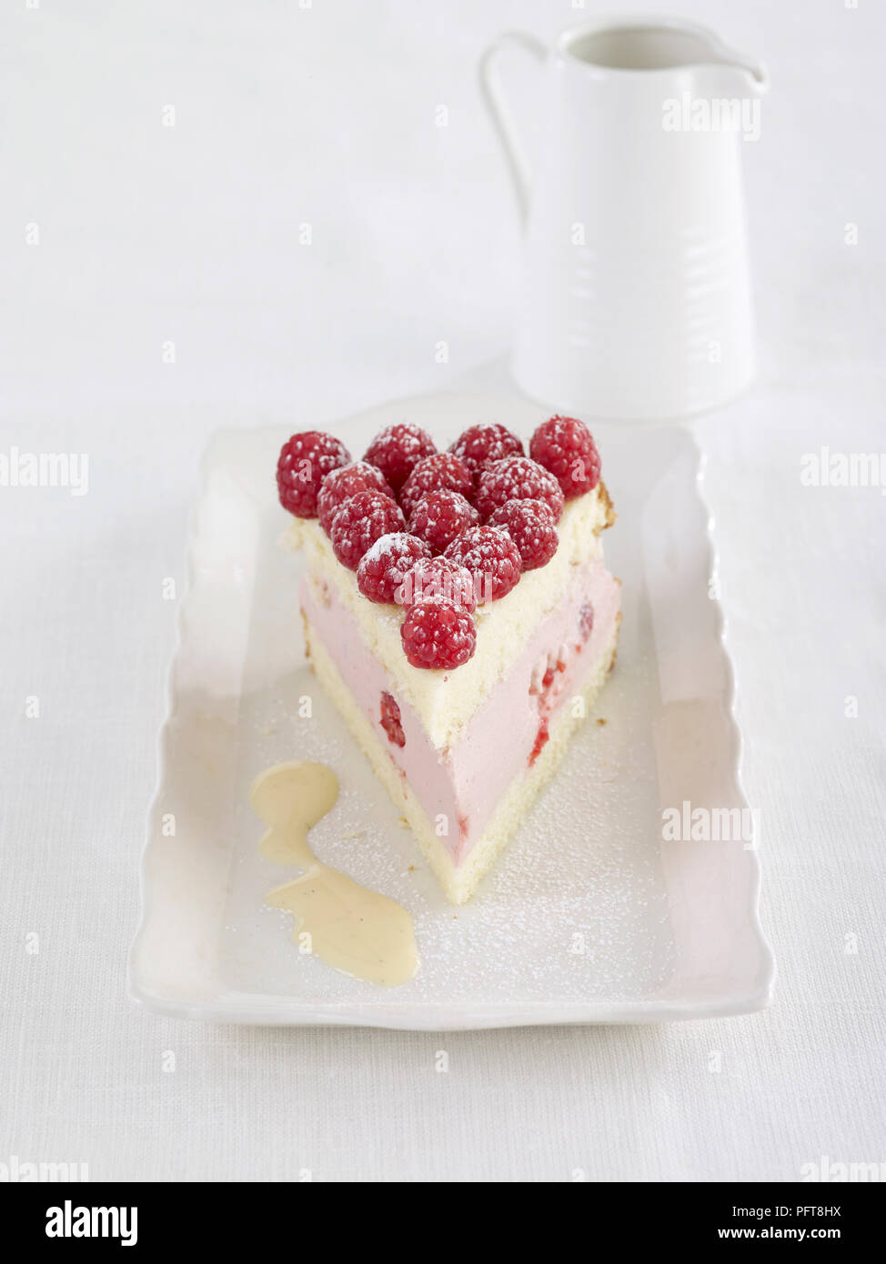 Raspberry bavarois served white plate with large jug of cream Stock
