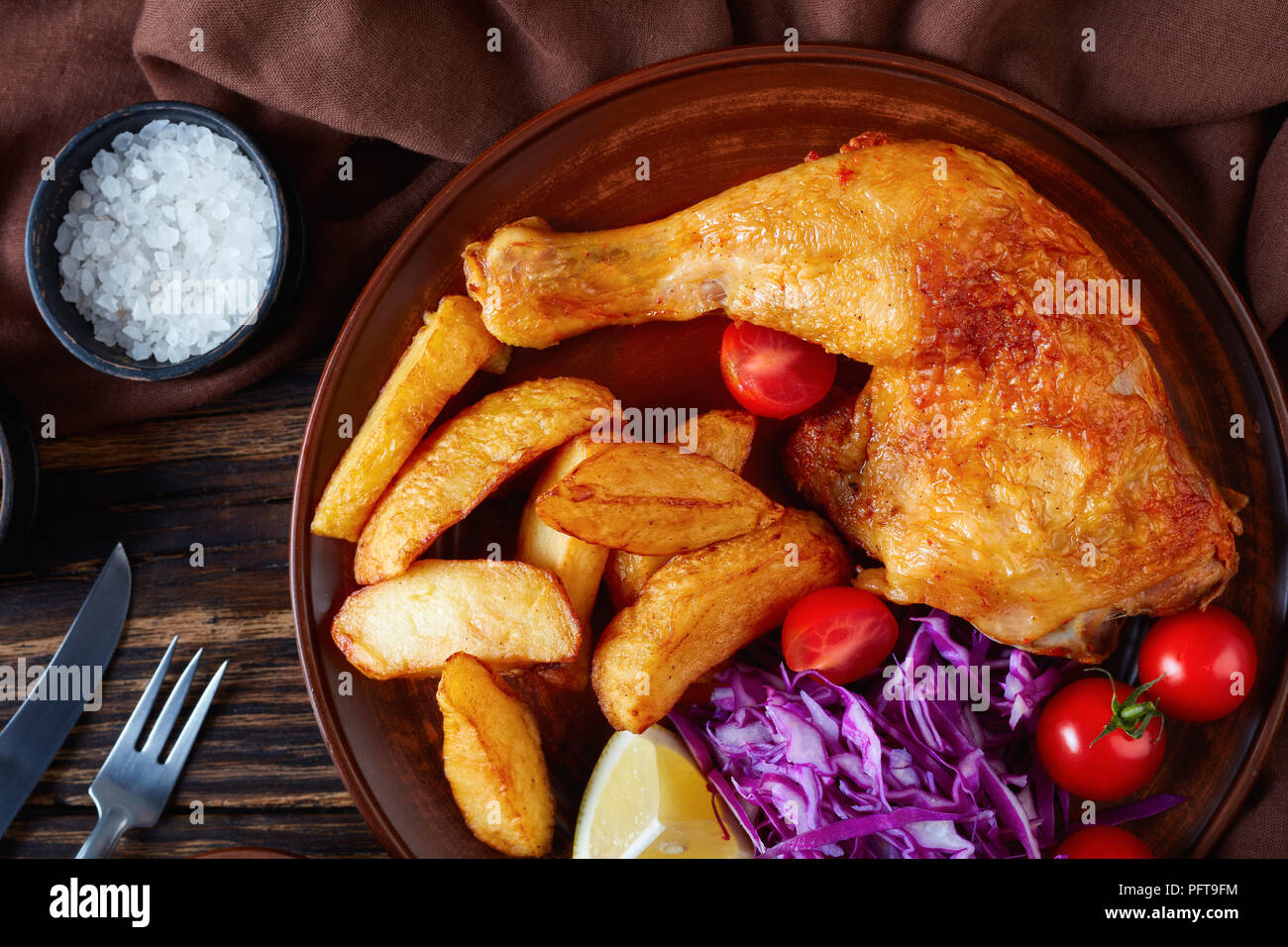 close-up of fried potato wedges ,chicken leg and coleslaw salad served
