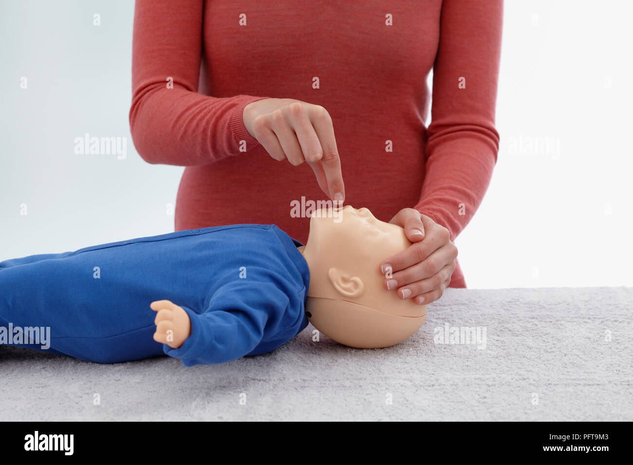 First aid medical checks and treatment of unconscious infant, using