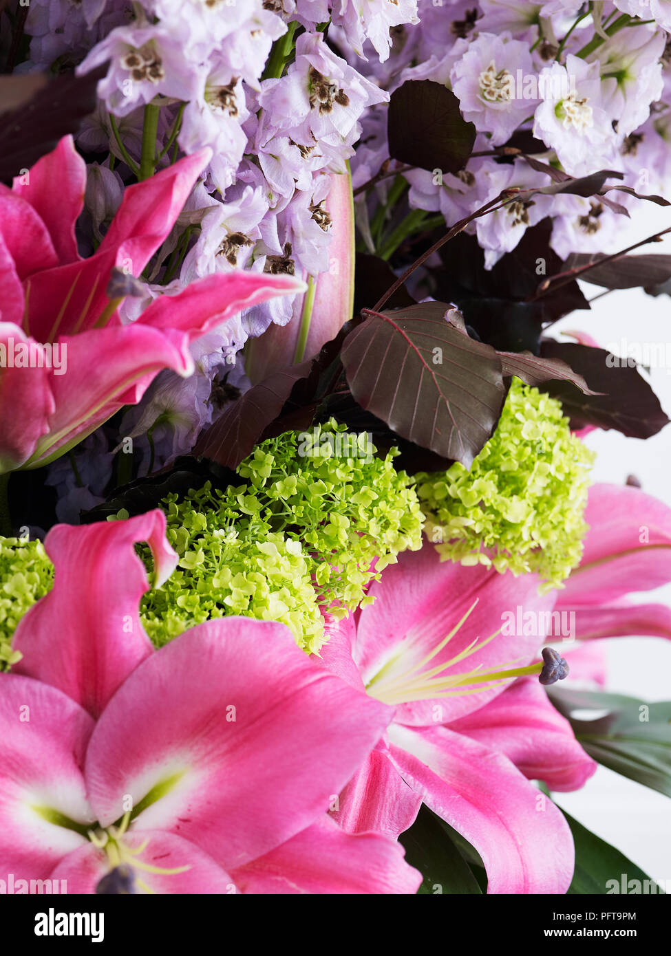 Layered flower arrangement, lilies, hydrangea, copper beech leaves, delphinium Stock Photo