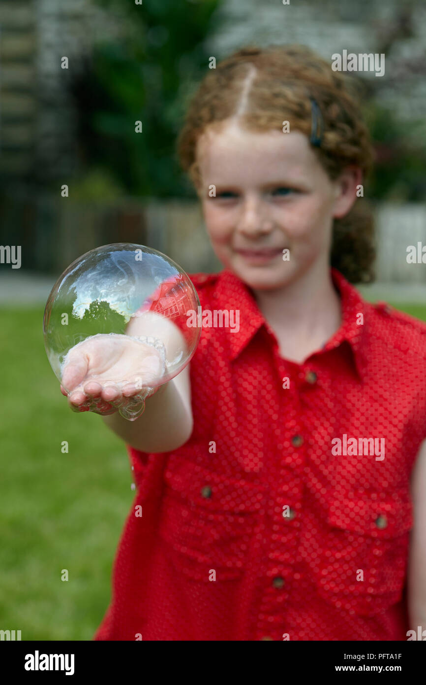 Blowing a hand bubble Stock Photo