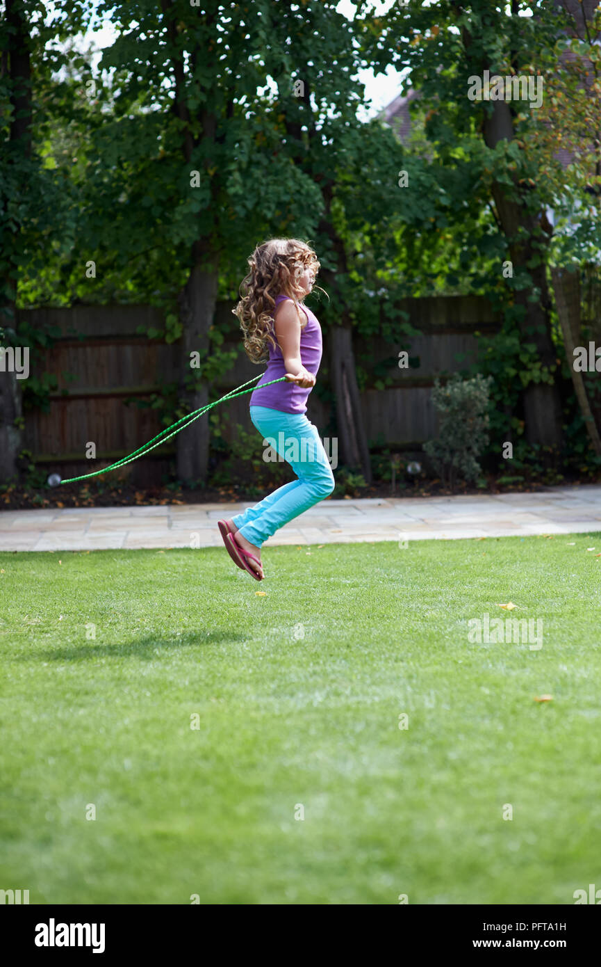 Girl skipping in garden Stock Photo